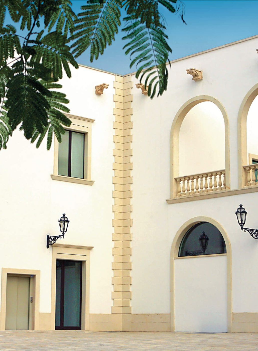 Palazzina bianca con archi e balcone della cantina Candido a San Donaci, nel Salento